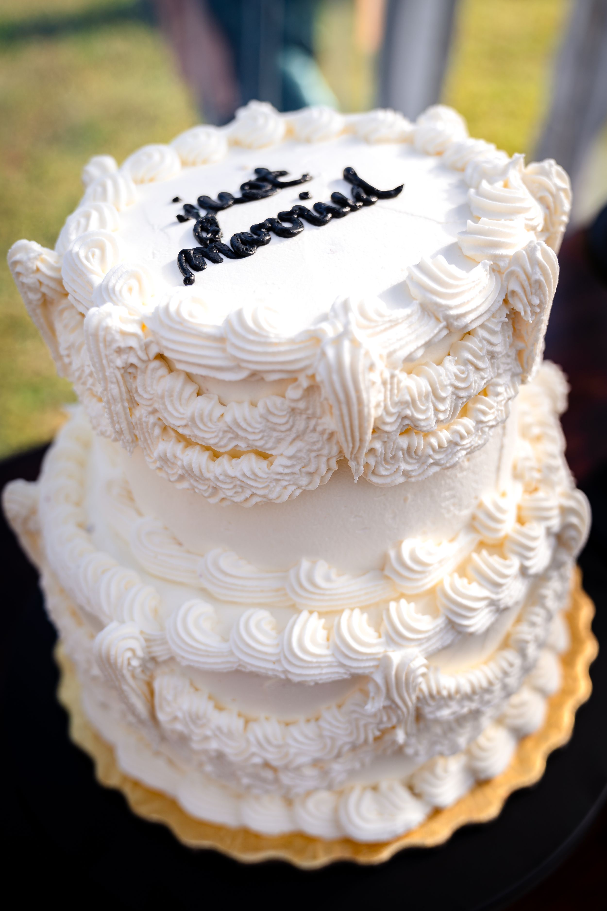 Elegant white wedding cake with intricate piped frosting details.
