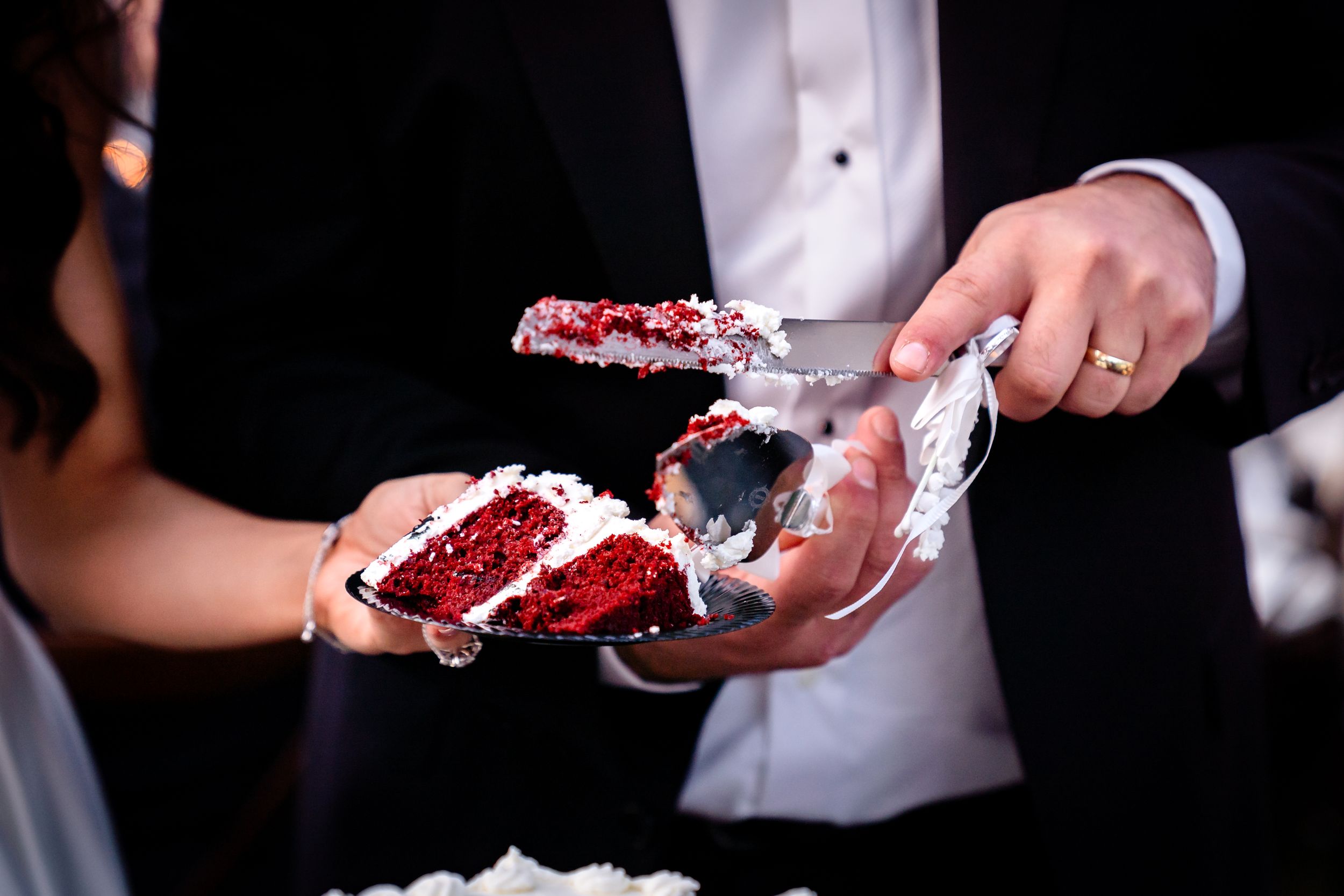 Close-up shots of red velvet wedding cake being served at reception.