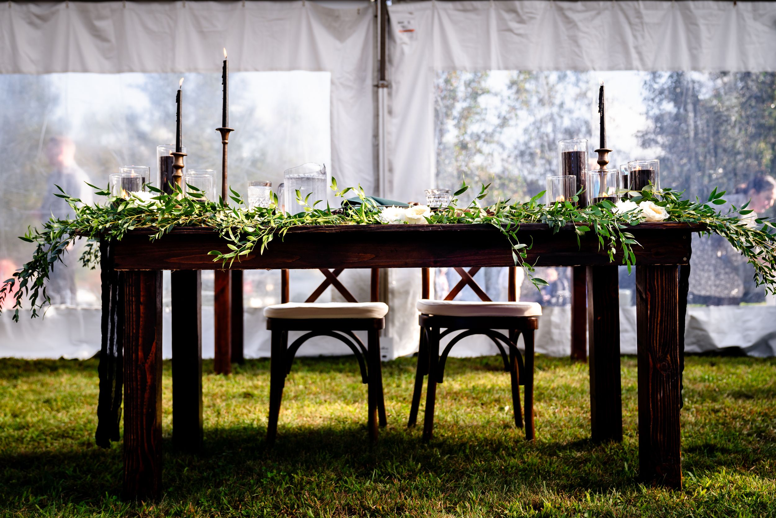 Rustic outdoor wedding venue with white tent and natural greenery.