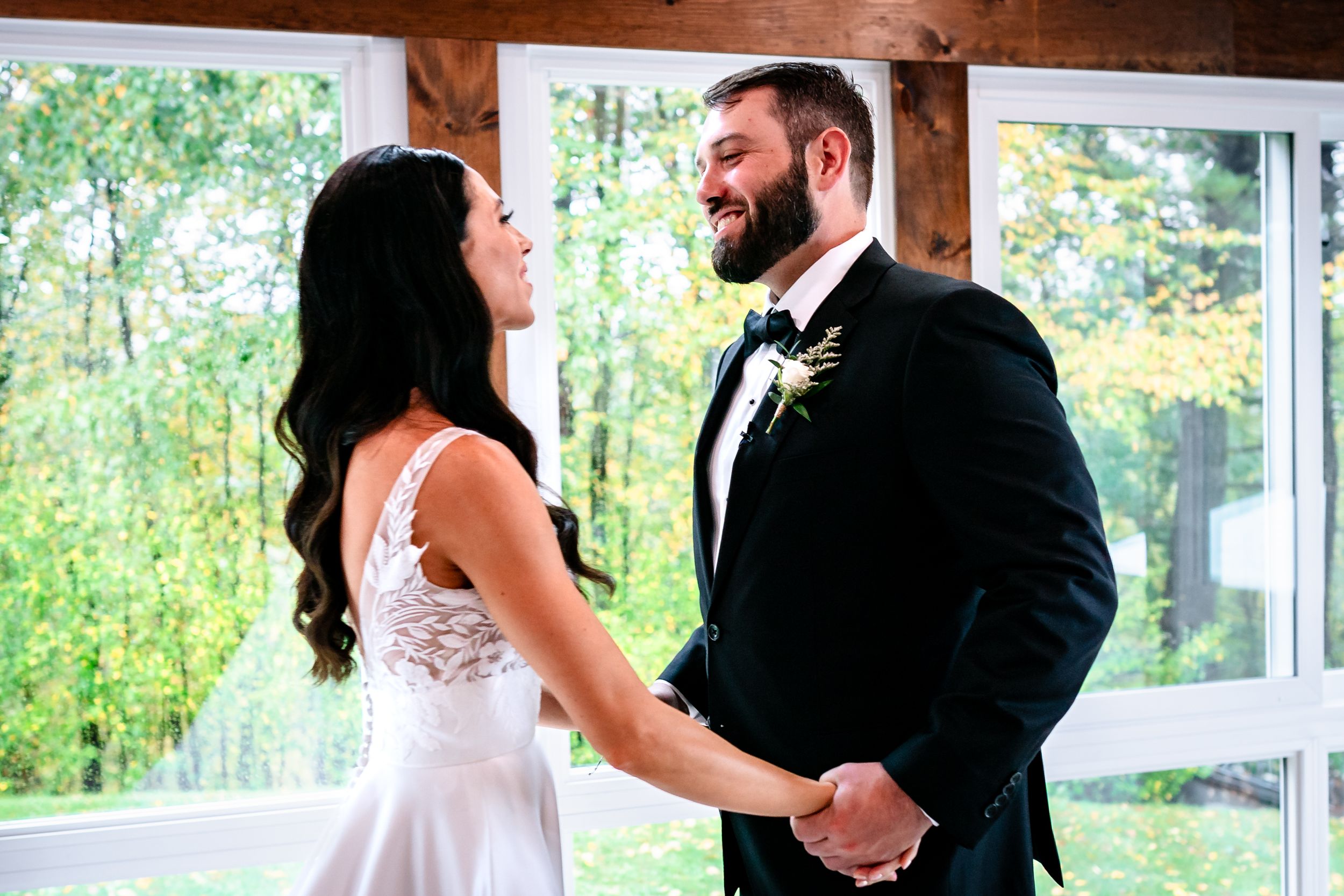 Wedding couple shares first dance in rustic venue with natural lighting.