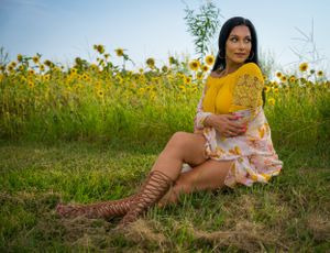 A dreamy summer portrait session among blooming sunflowers with natural lighting.