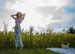A dreamy sunflower field photoshoot under bright blue skies with tall yellow blooms.