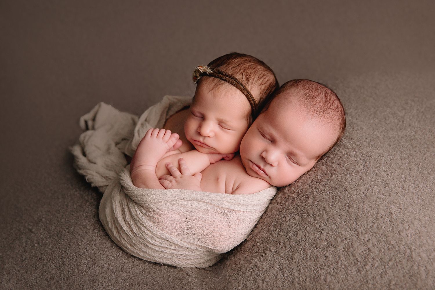newborn twins sleeping and posed together for studio newborn photoshoot near overland park KS