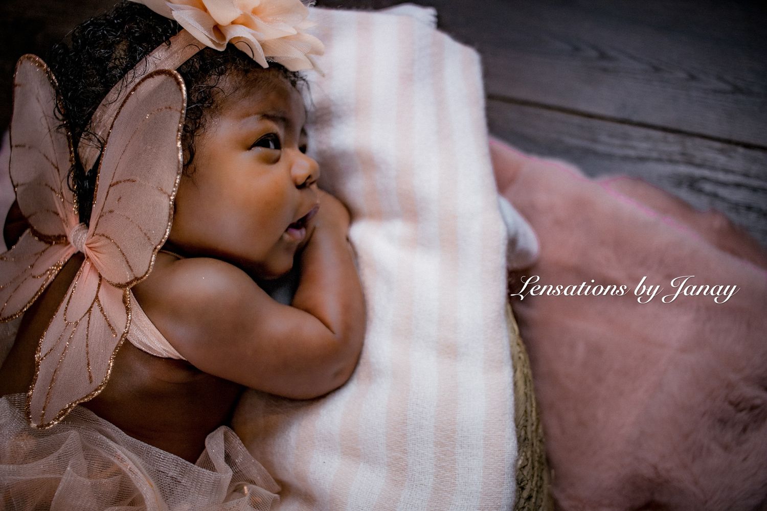 Newborn baby with butterfly wings sleeps peacefully in a basket.