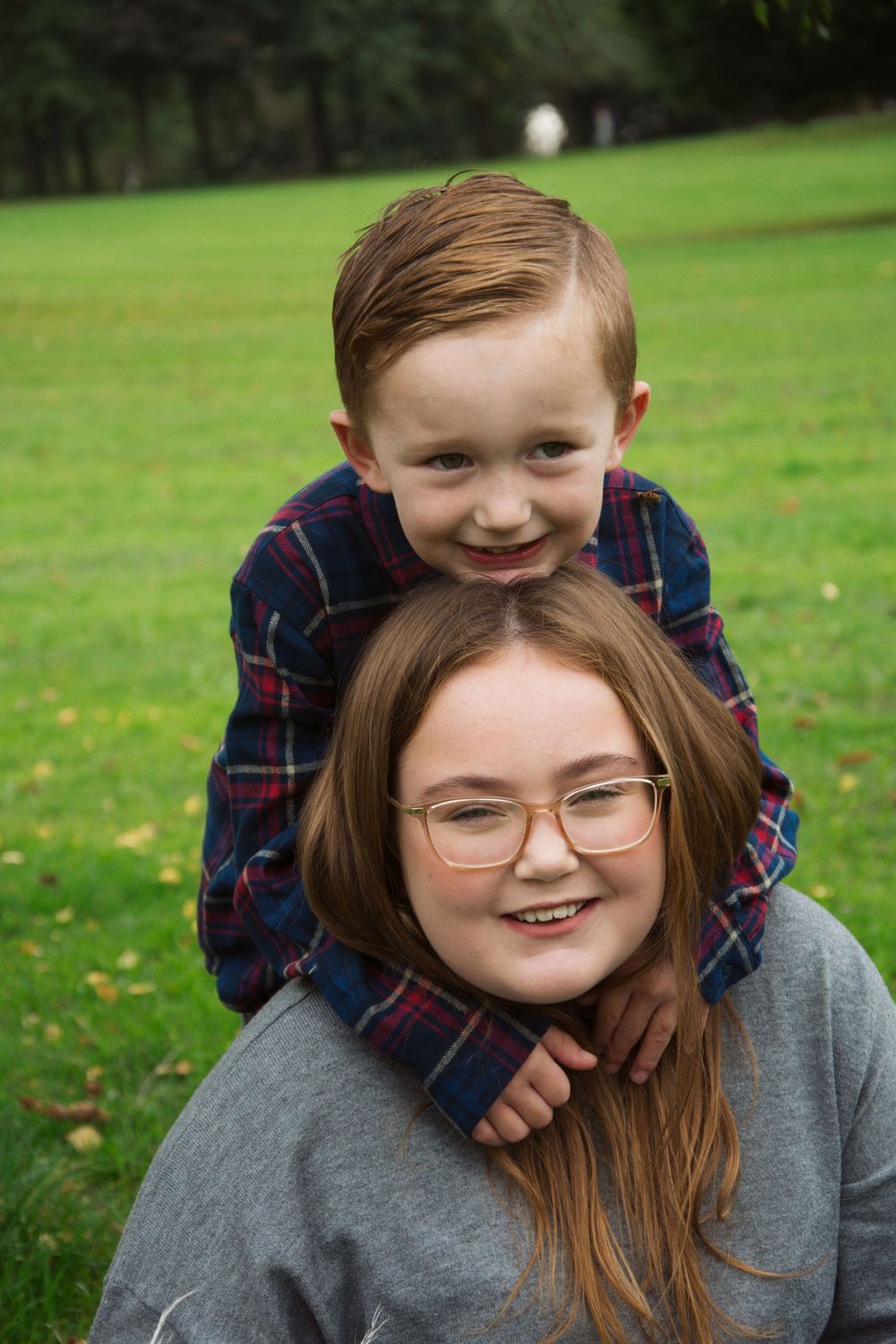 Heartwarming outdoor portrait showing playful bonding moment on green lawn.
