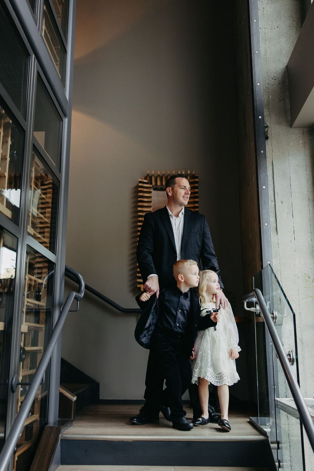 A family standing together on industrial-style stairs with modern decor.