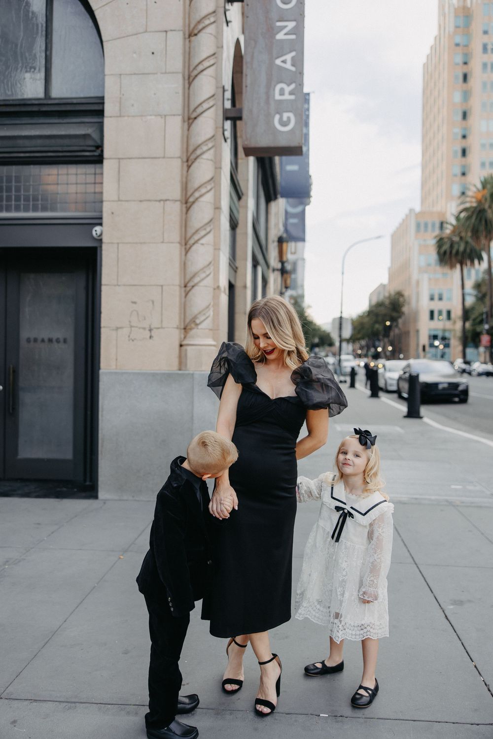 A stylish urban family photo outside a building on a city street.