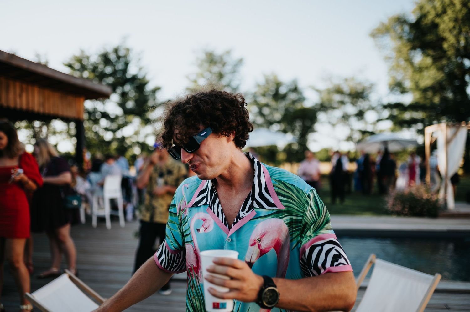 Guests enjoying drinks and conversation at a rustic outdoor wedding venue.