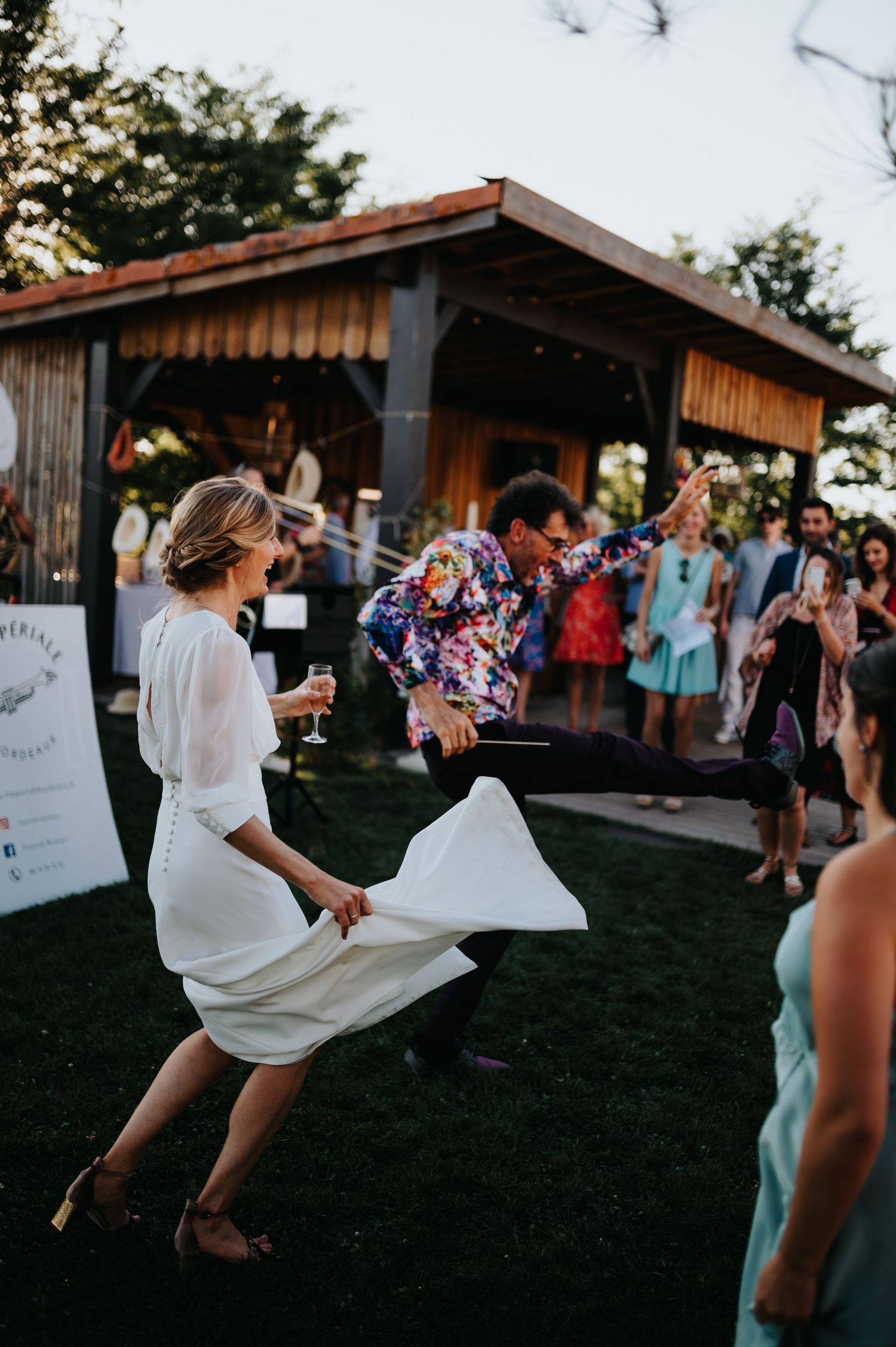 Energetic dancing and celebration at a rustic outdoor wedding venue.