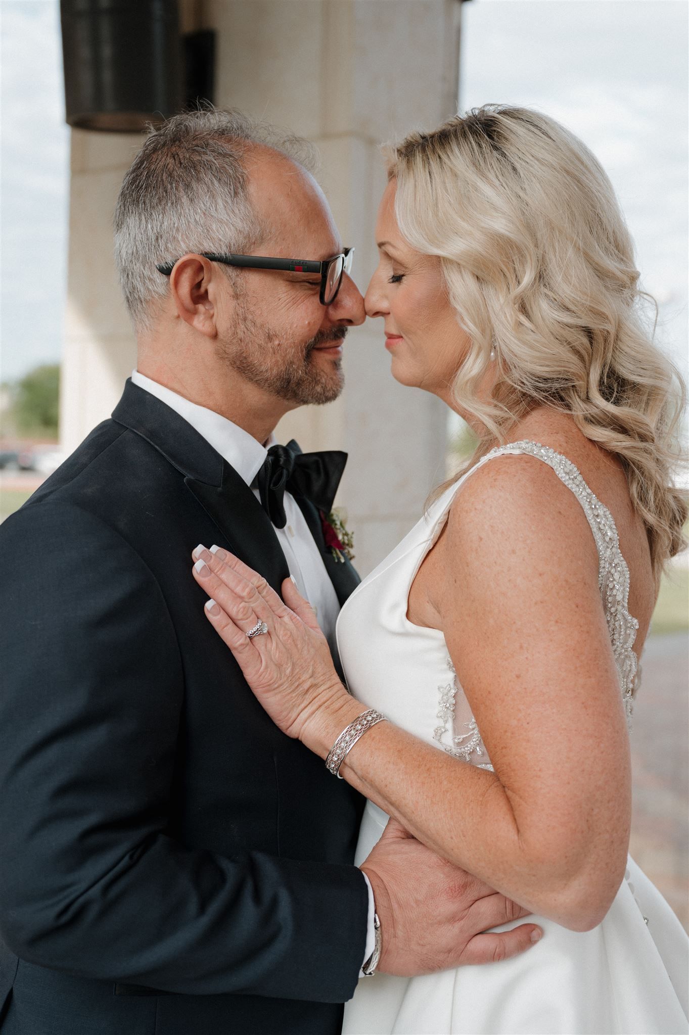 Close-up romantic moment between couple in formal wedding attire.