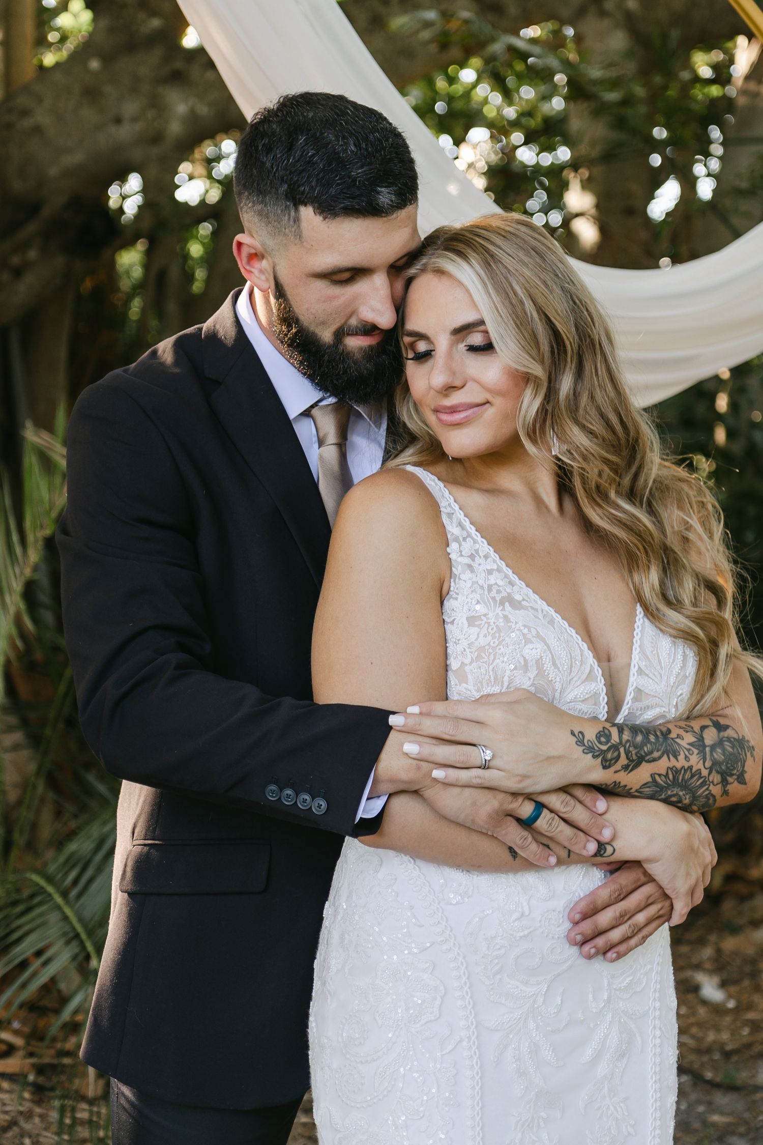 Groom holding bride on their wedding day in Bradenton Florida. Captured by wedding photographers Bradenton