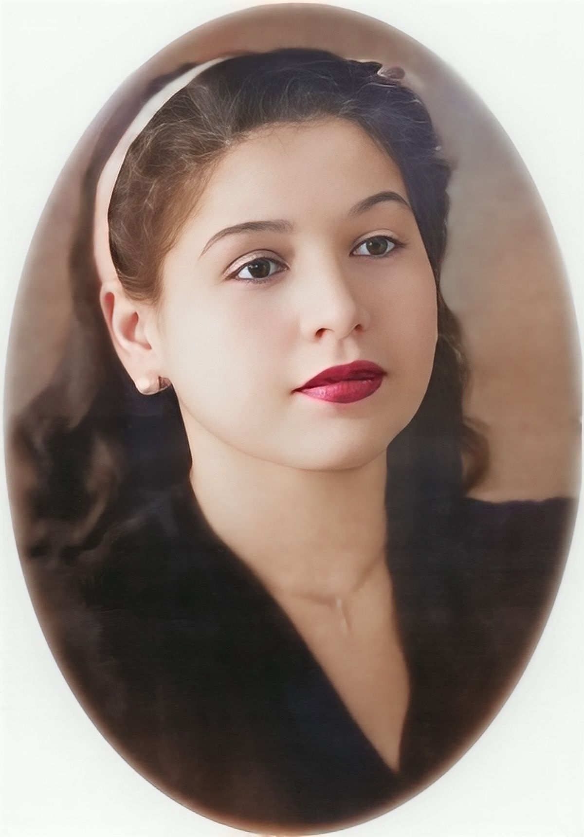 Oval portrait in soft focus featuring a vintage-style photo with classic makeup and dark clothing against neutral background.
