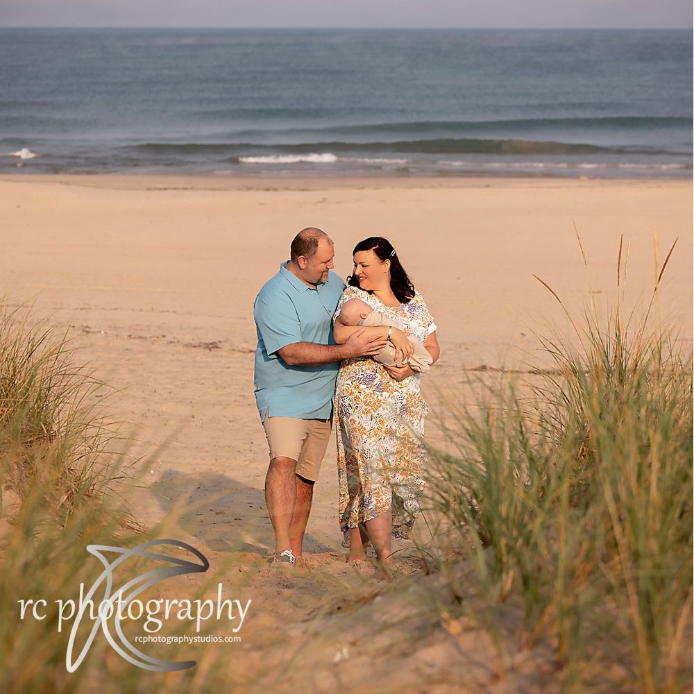 Romantic beach photoshoot during sunset with sand dunes and sea grass in the background.