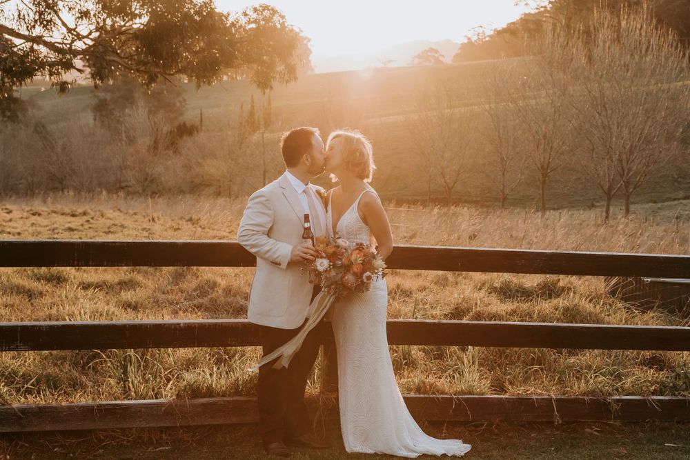 Golden sunset light creates silhouettes during romantic outdoor wedding portraits.