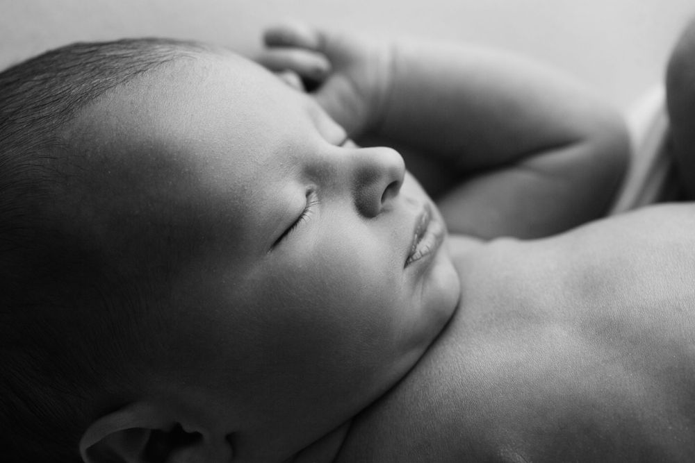 Black and white image on newborn baby boy closeup profile.