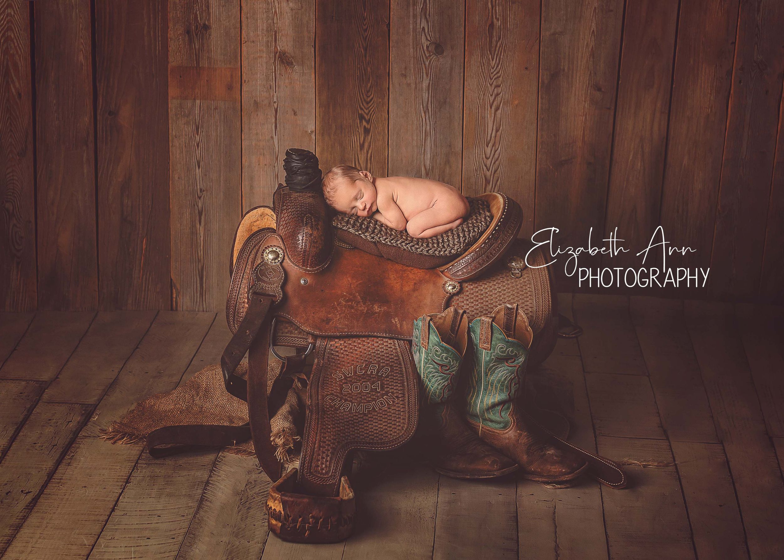 Rustic barnwood studio portrait, newborn with a saddle with cowboy boots, by Elizabeth Ann Photography, Wisconsin, USA,