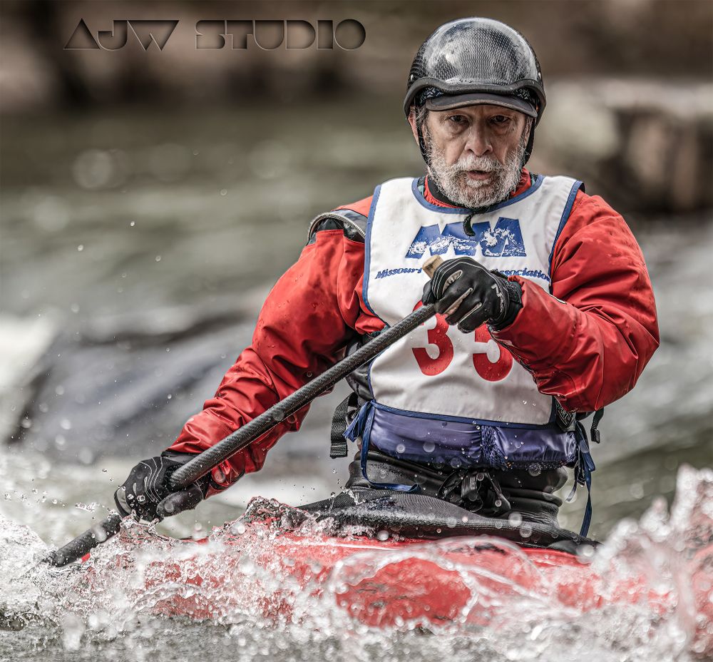 Kayaker in red jacket navigates whitewater rapids in competitive race.