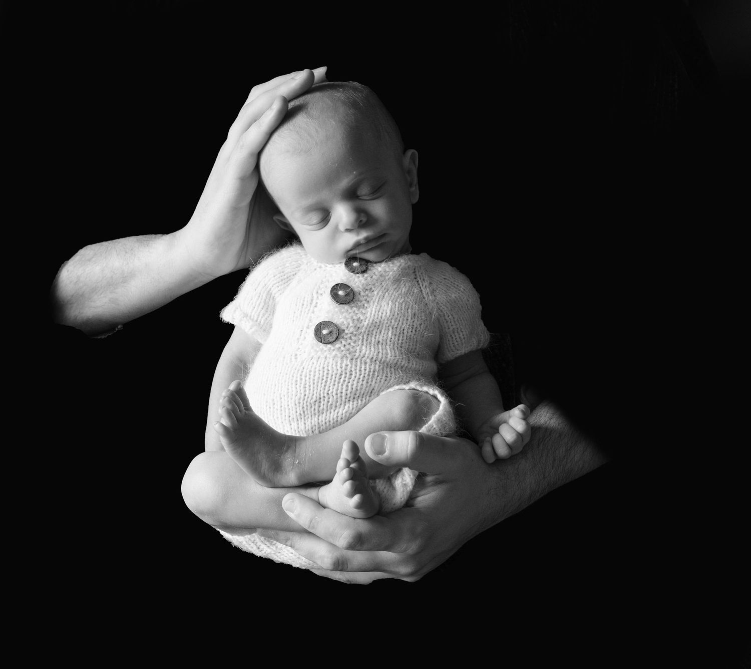 Black and White Fine Art image of newborn being held by father during newborn photoshoot with Sweet Sol Photo, in Queens