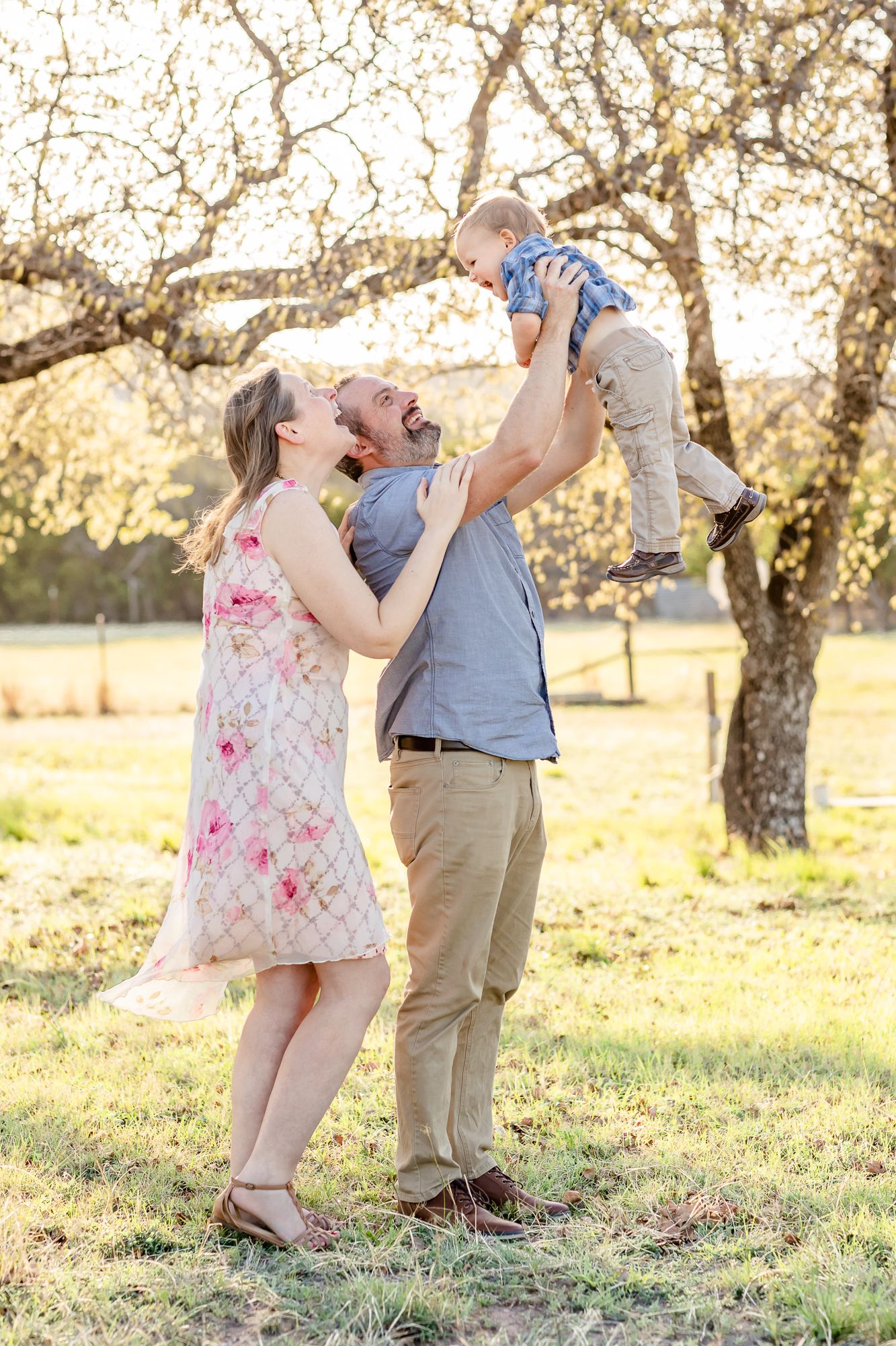 Parents lift their toddler boy into the air and smile as he giggles in Abilene, Texas.