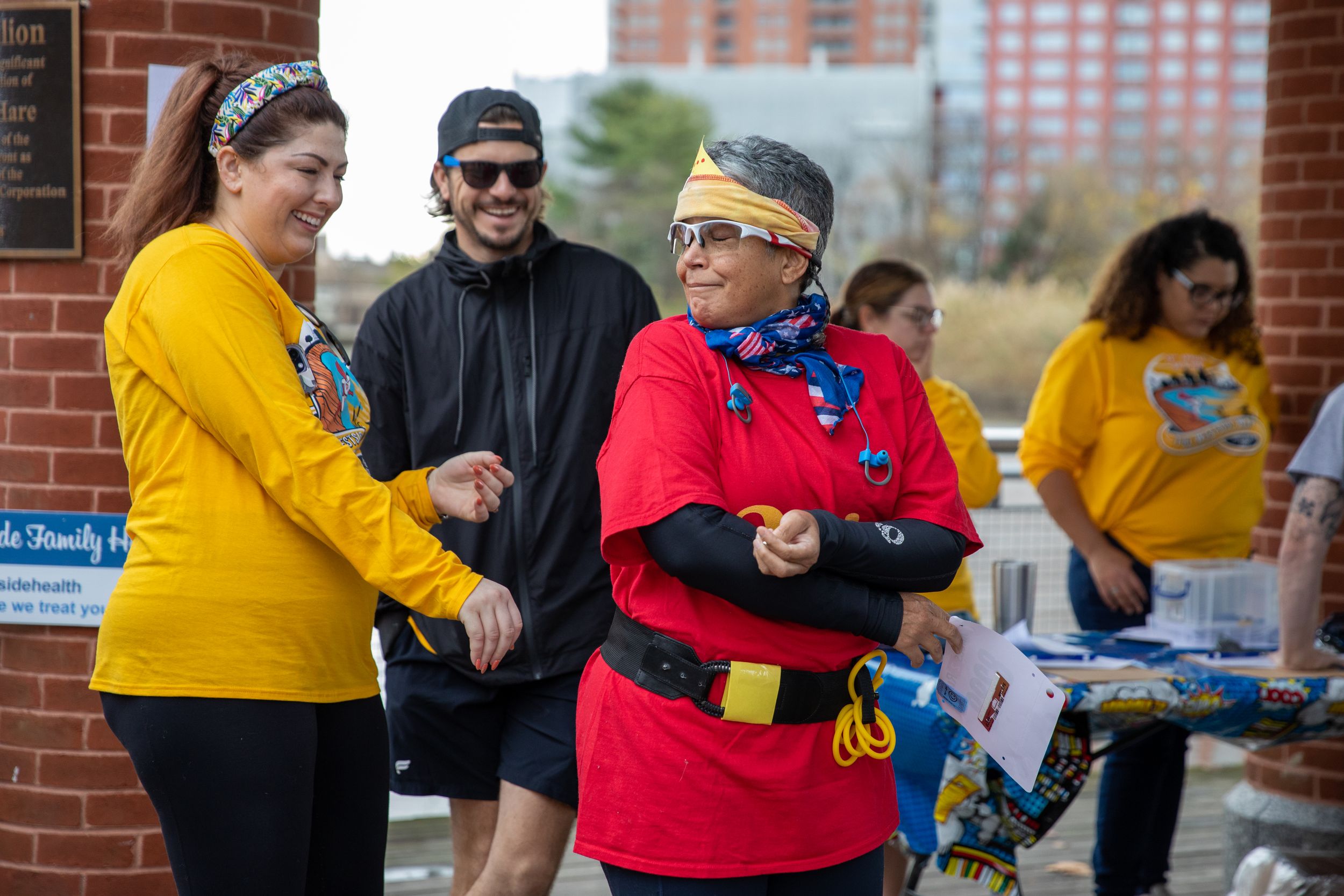 People in yellow and red shirts gathered at an outdoor community event.