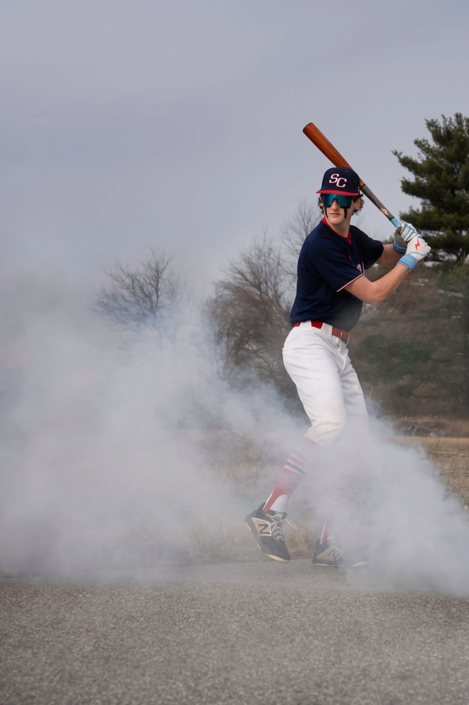 Baseball player in batting stance surrounded by atmospheric fog during practice.