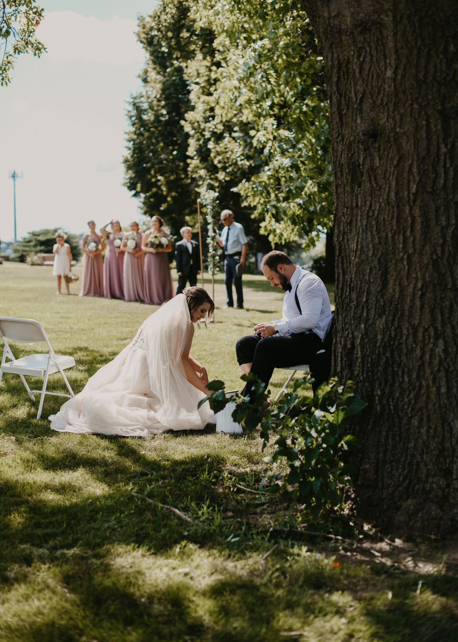 Couple washing each others feet at private Wedding ceremony outside