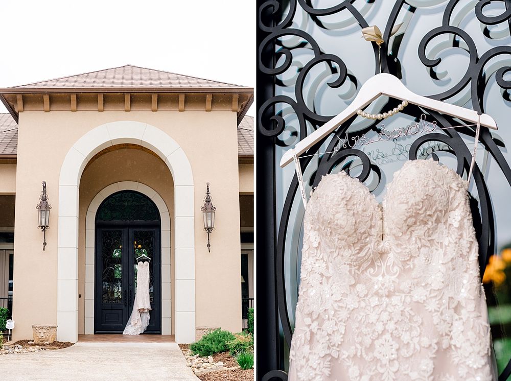 Ornate doorway of a cream-colored venue with decorative wrought iron details and a wedding dress display.