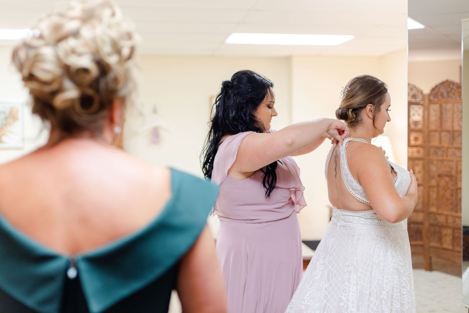 Wedding preparation scene with bridesmaids in purple dresses helping with final touches.