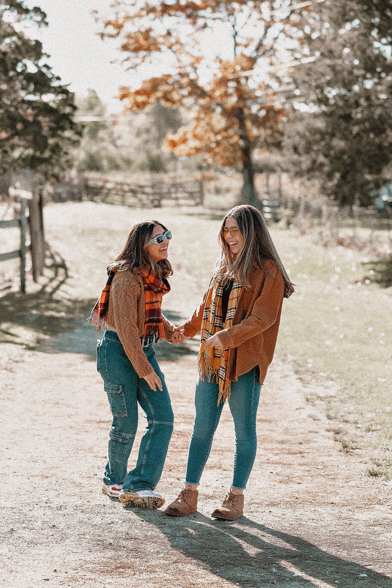 Candid autumn moment on a sunlit country path with matching fall outfits.