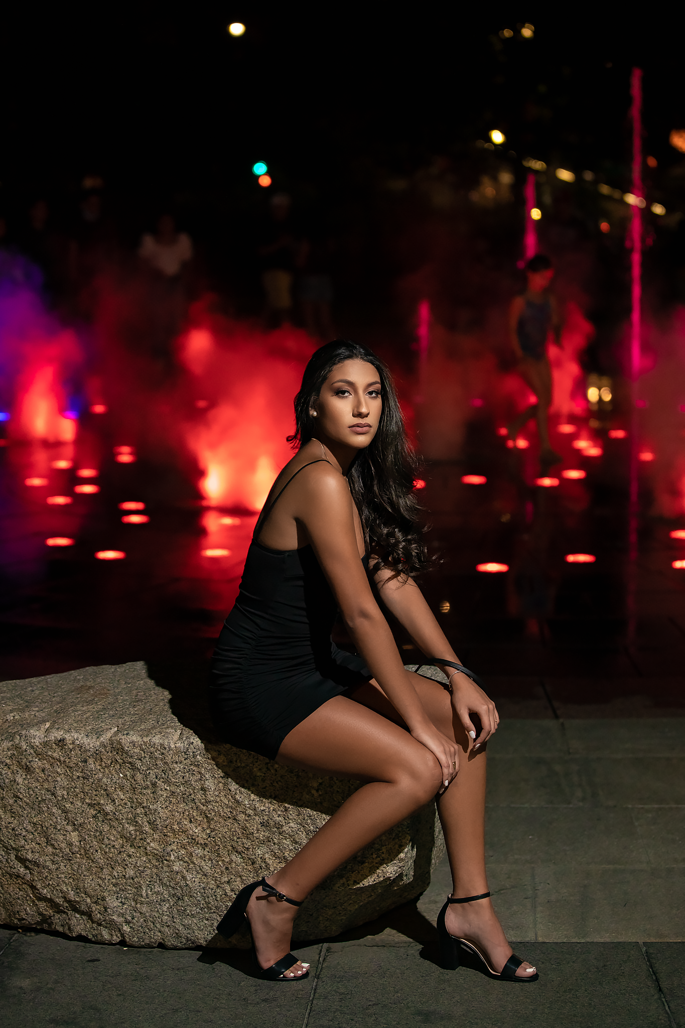Dramatic nighttime photo with red lighting and stone features creating moody ambiance.