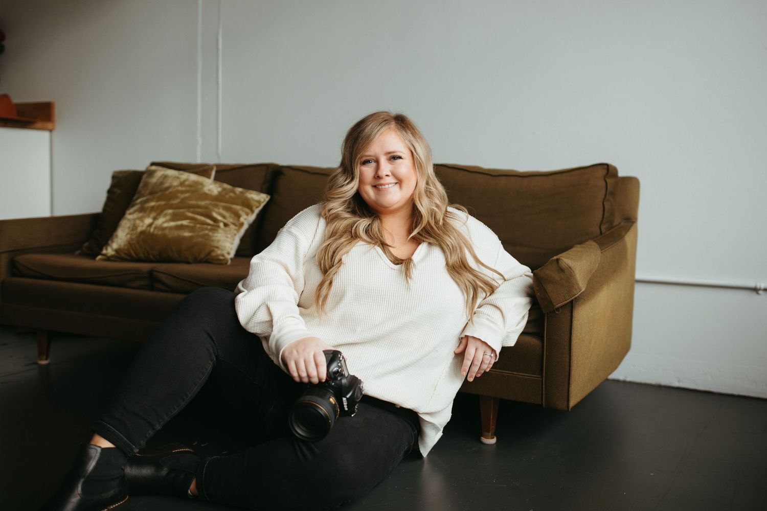 Lifestyle photography session on brown leather couch in minimalist setting.