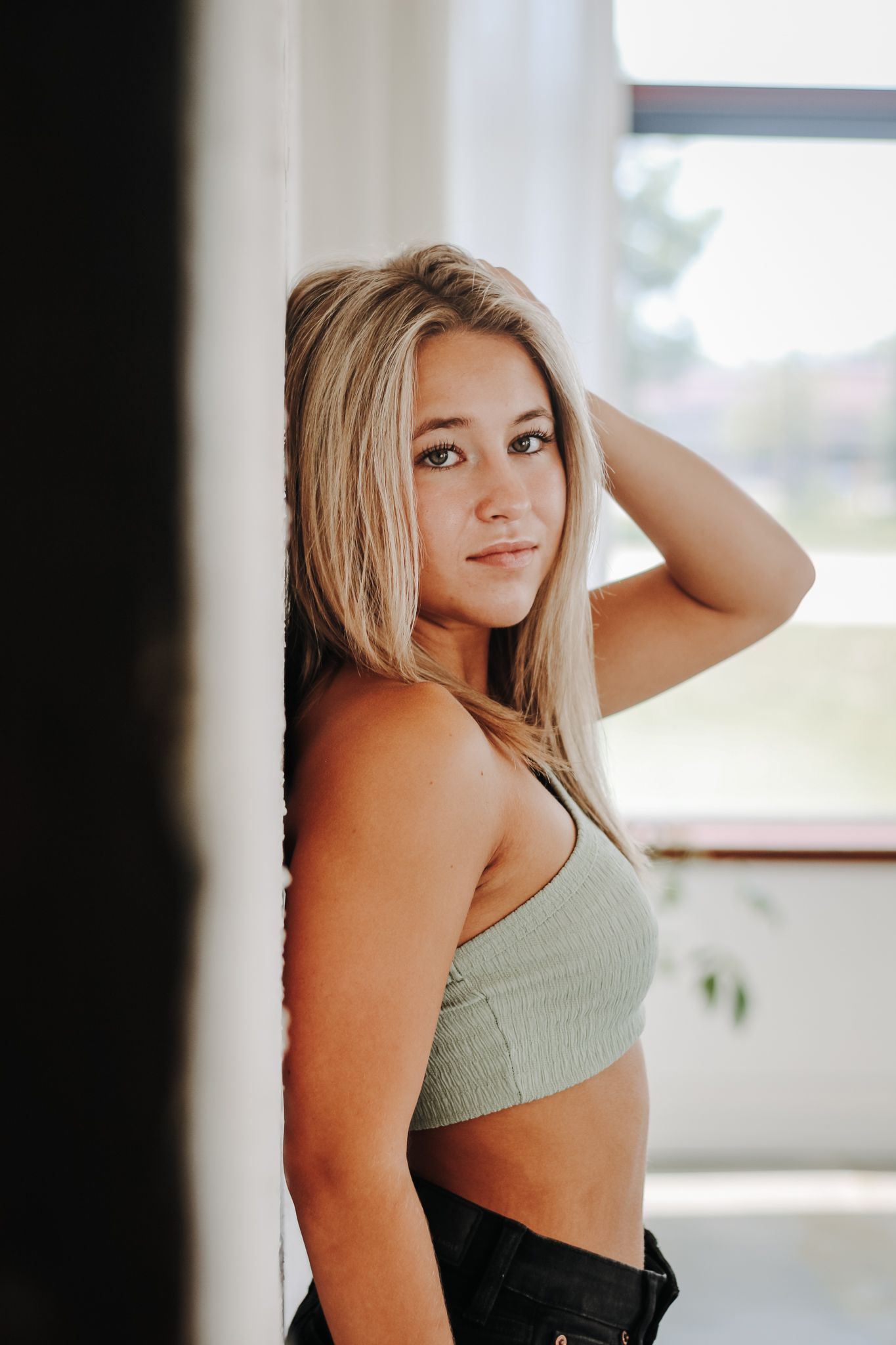 Lifestyle portrait in a bright interior setting with natural window light.