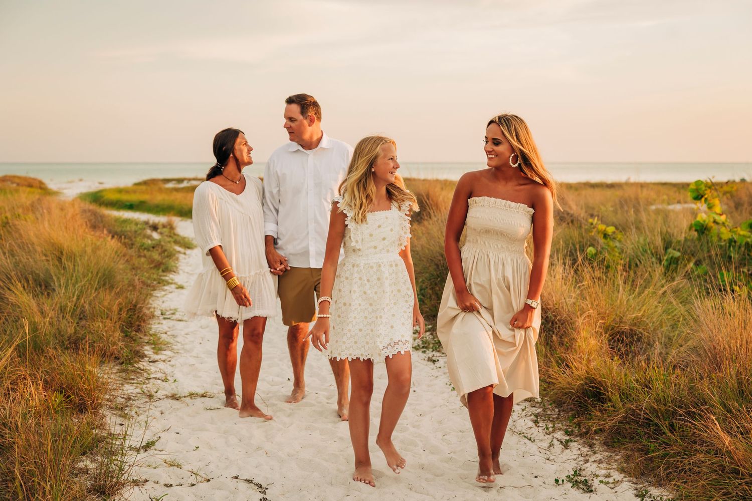 Family walking down the beach path at Siesta Key Beach at sunset taken by Sarasota family photographer.