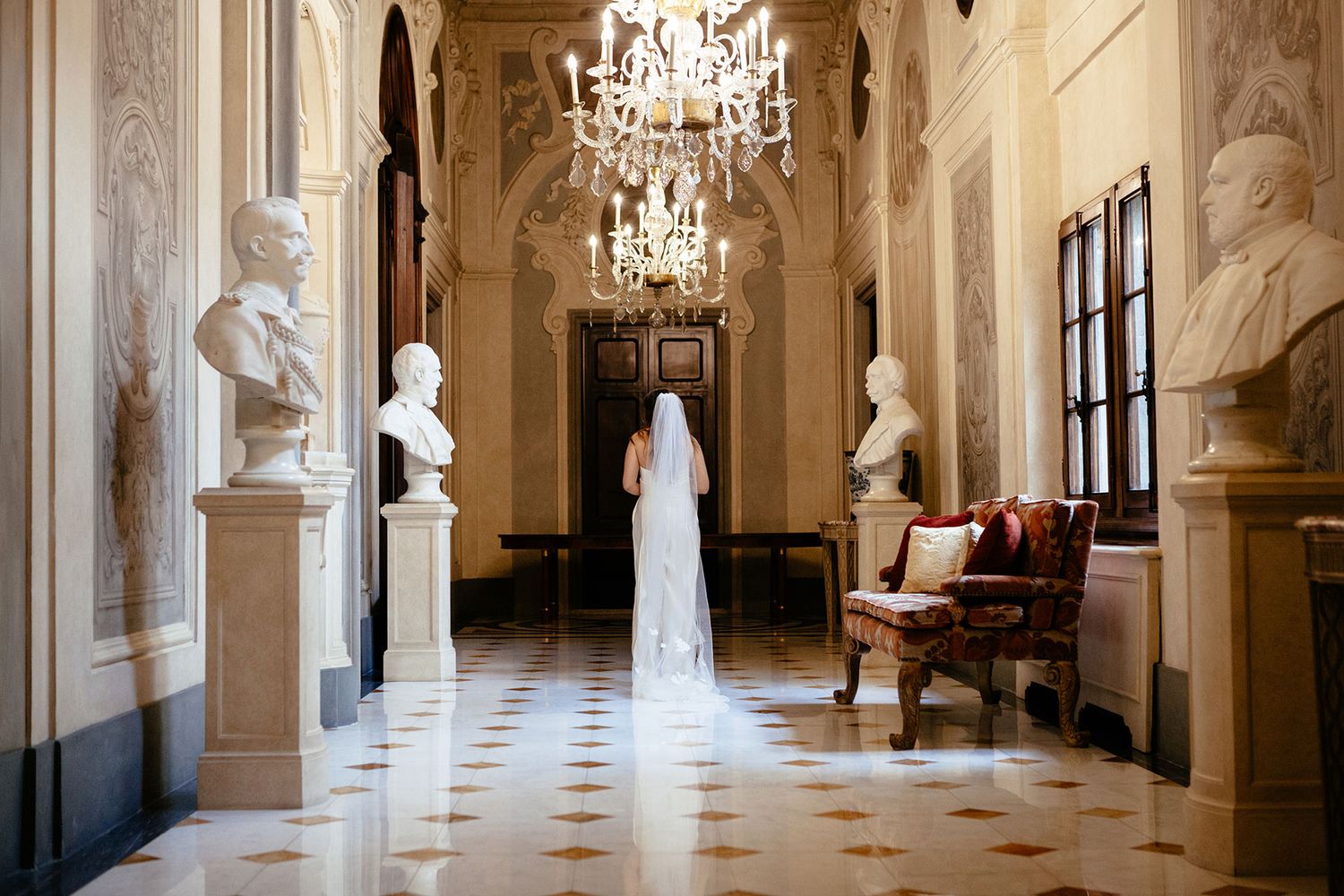 bride in a white jumpsuit walks down the corridor of the Four Seasons Hotel in Florence Tuscany before her wedding