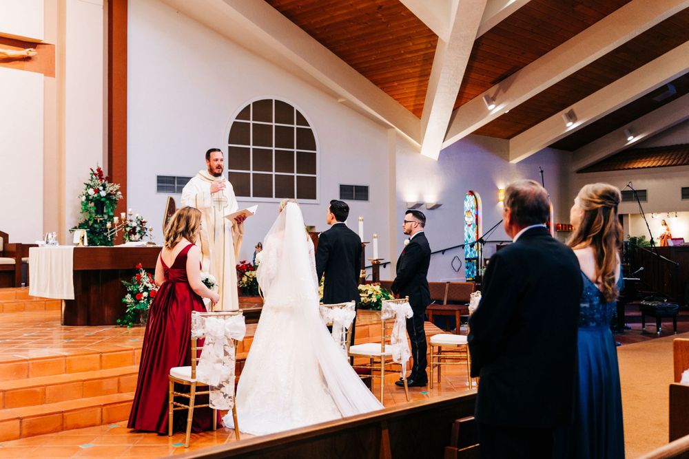 Traditional church wedding ceremony in progress with wooden beam cathedral ceiling.