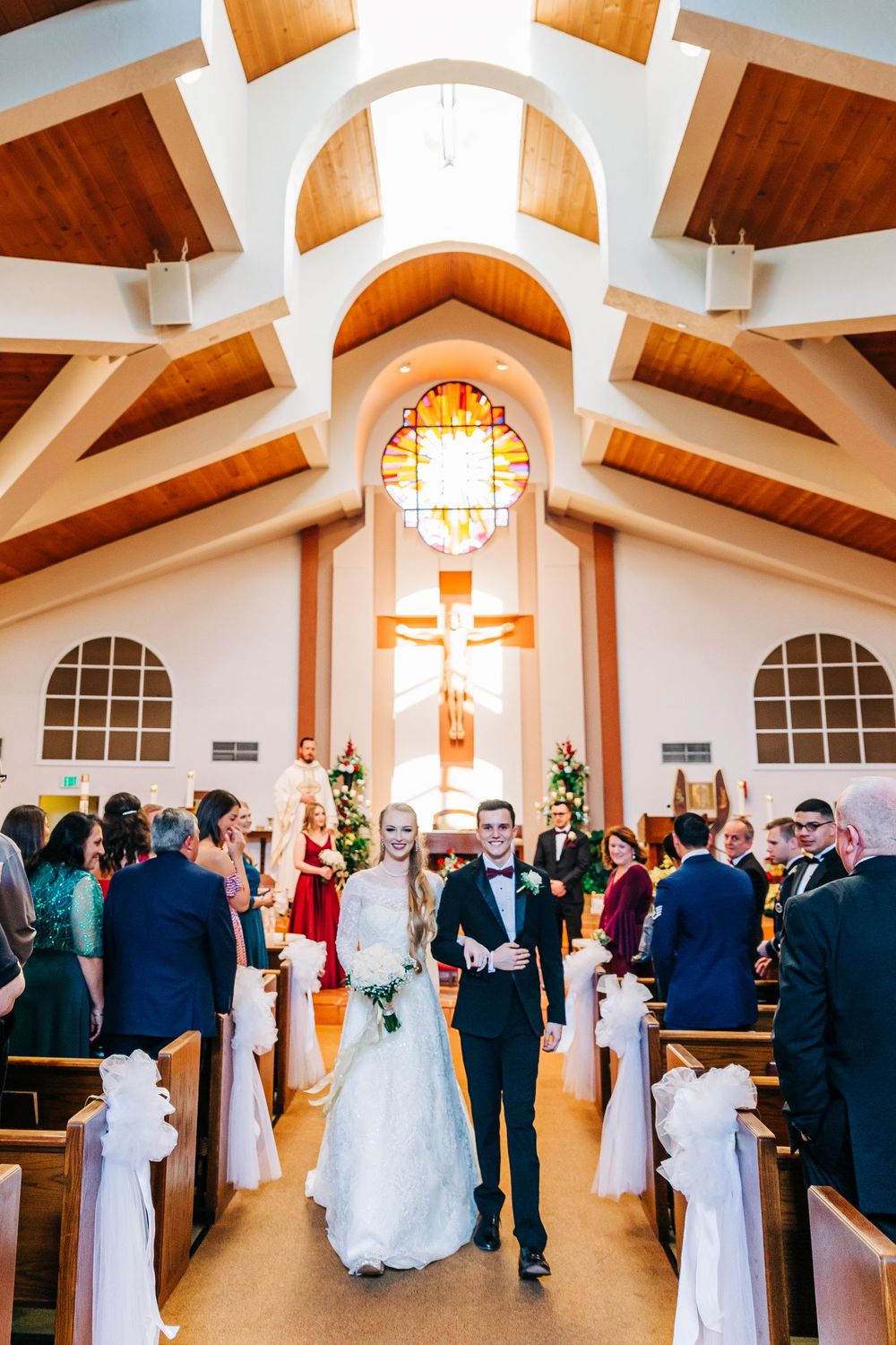 A priest signs documents during a wedding ceremony in a church interior.