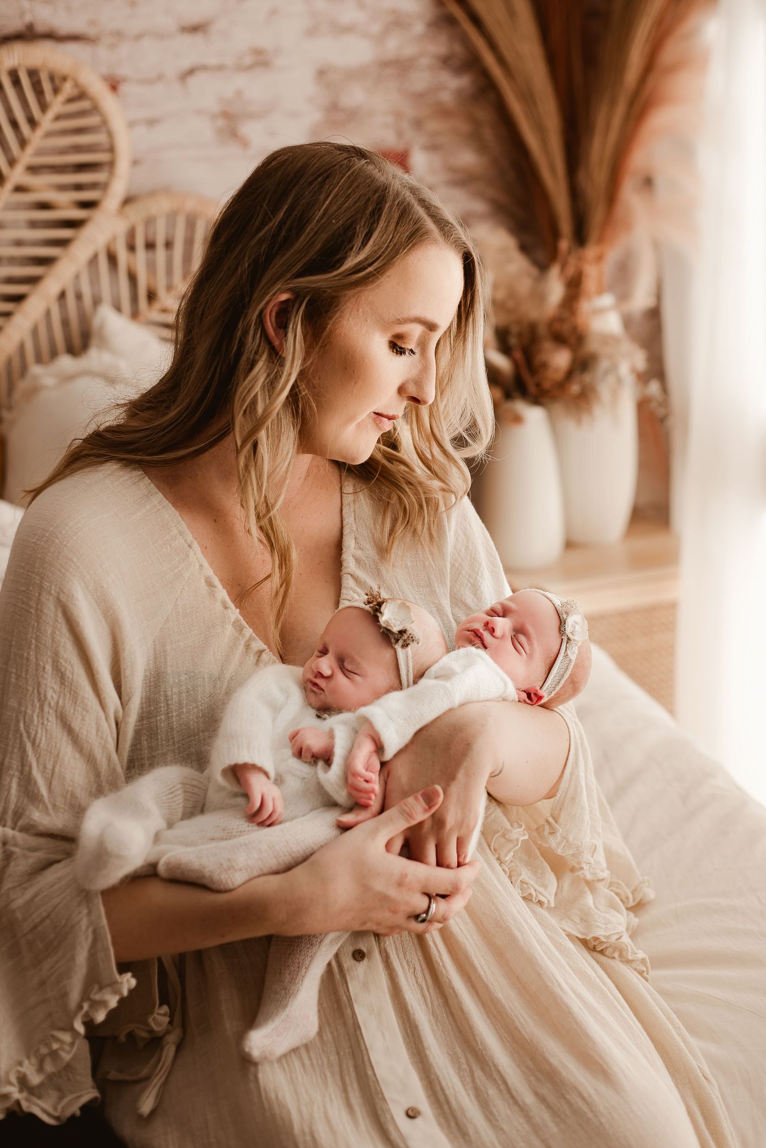 Tender moment between parent and newborn baby in a cozy boho-styled nursery with palm fronds.