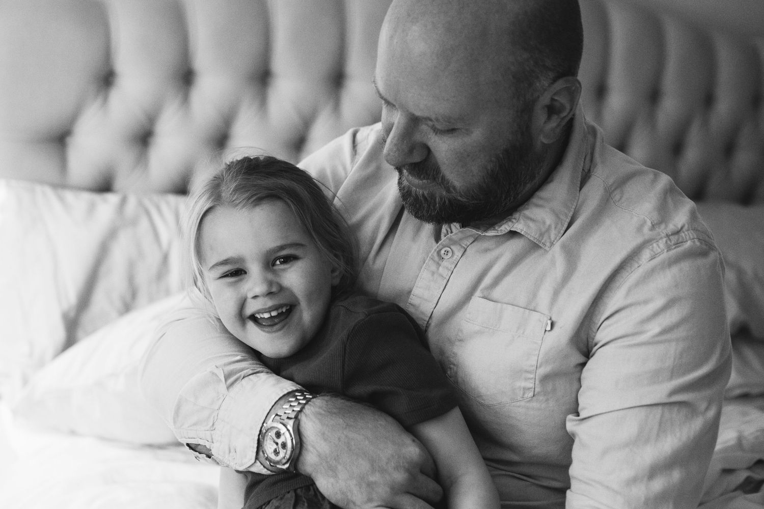 A heartwarming black and white portrait capturing tender playtime moments on a couch.