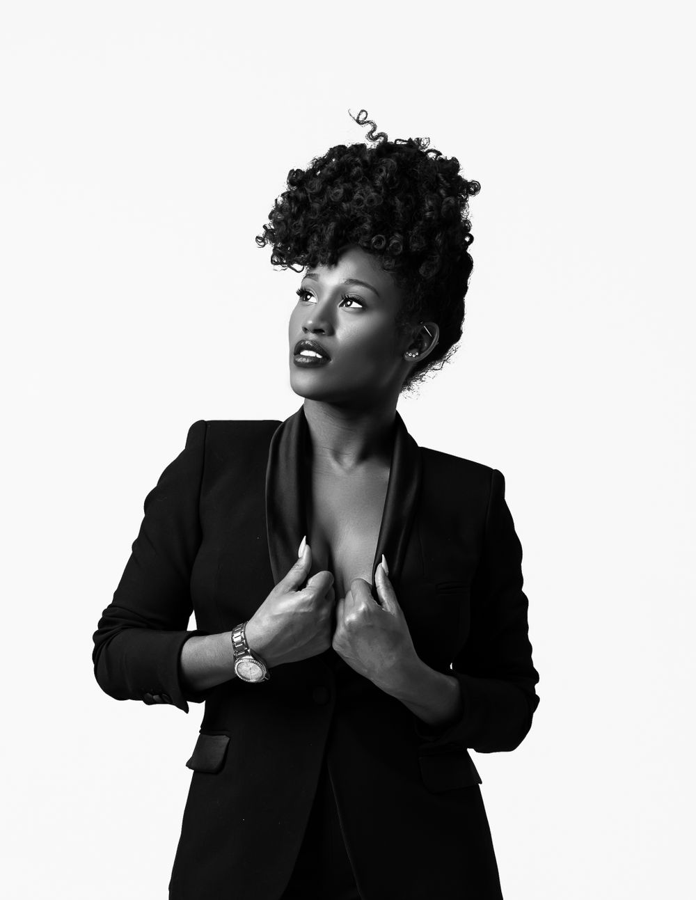 Dramatic black and white portrait showcasing natural curls and a sophisticated black blazer.