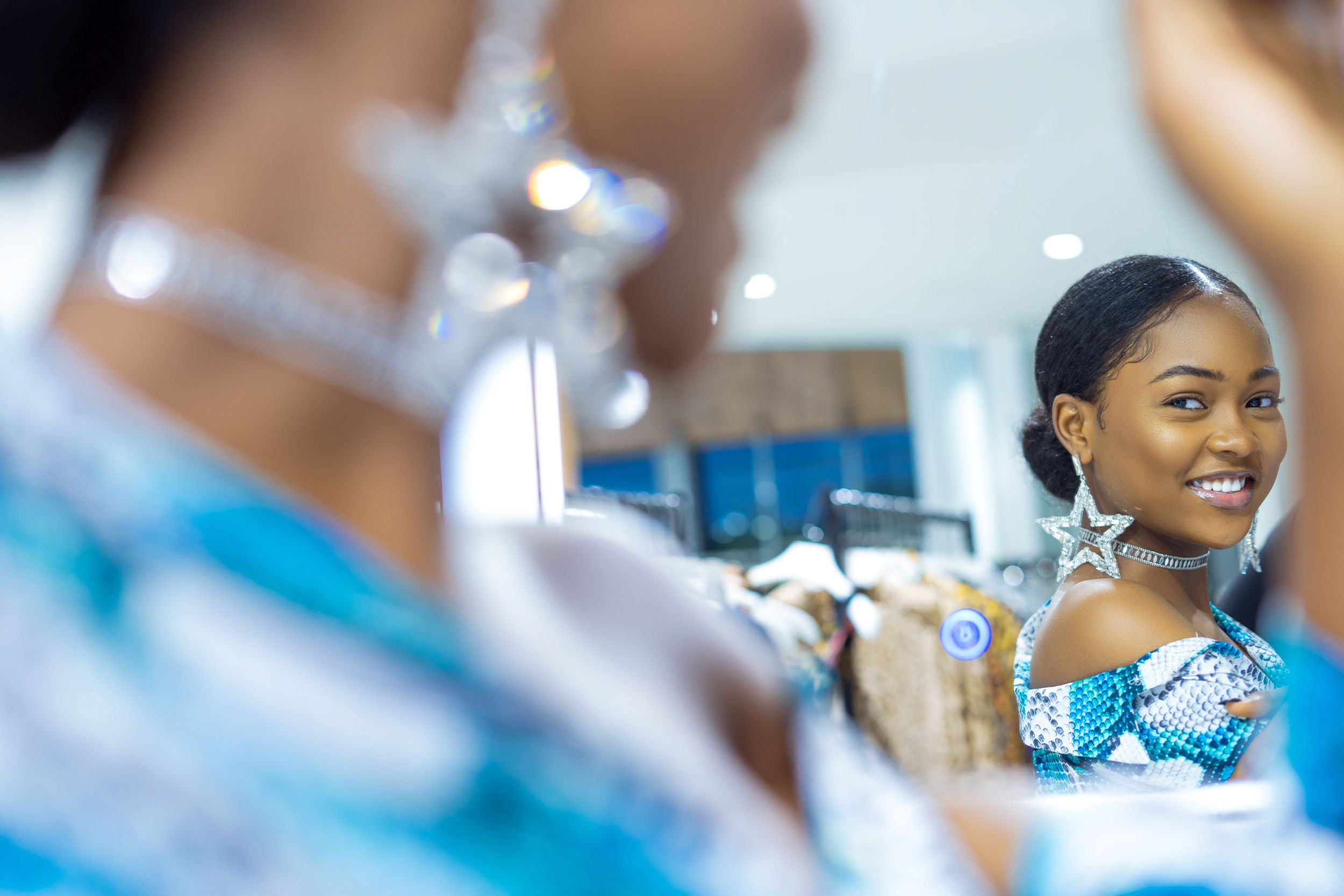 Elegant reflection in mirror showing sparkly blue formal attire.