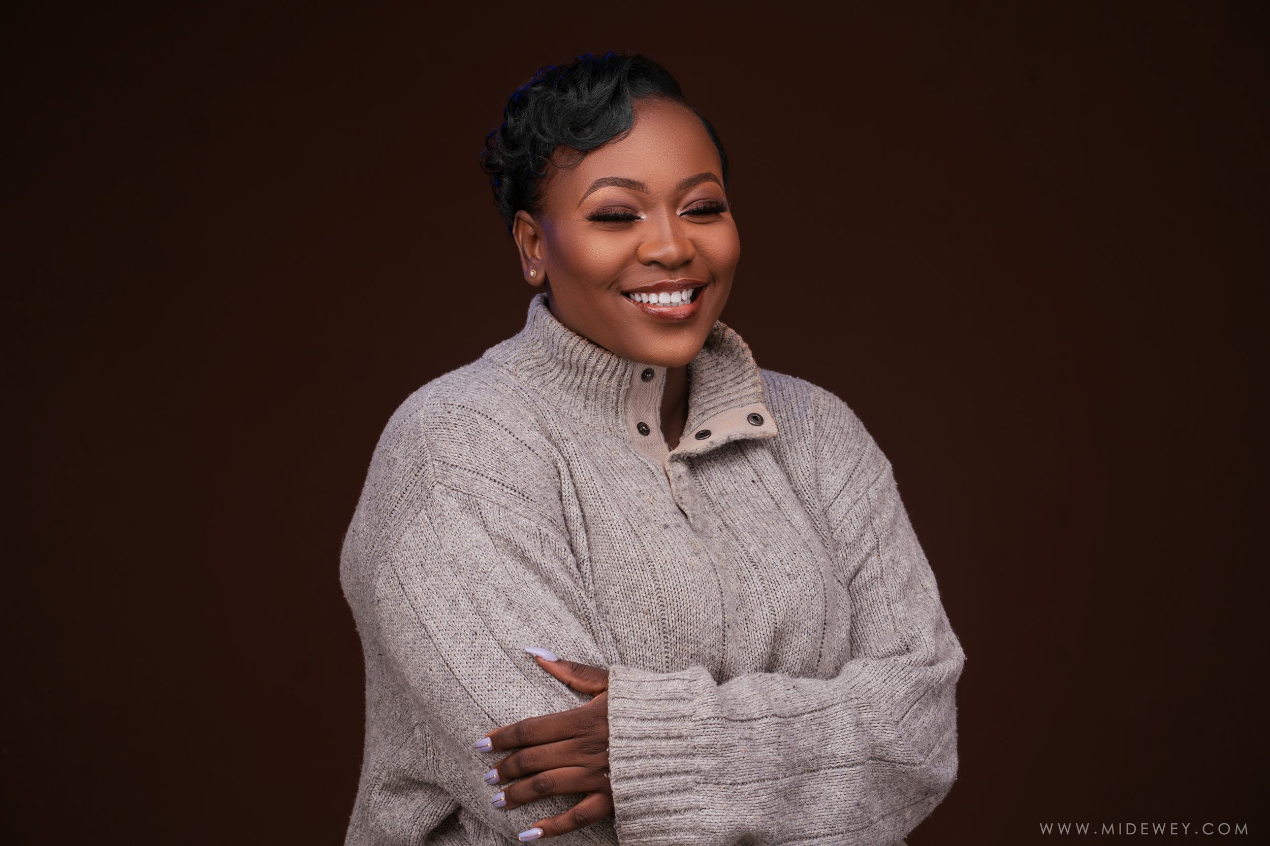 Warm studio portrait featuring cozy beige turtleneck sweater against dark background.