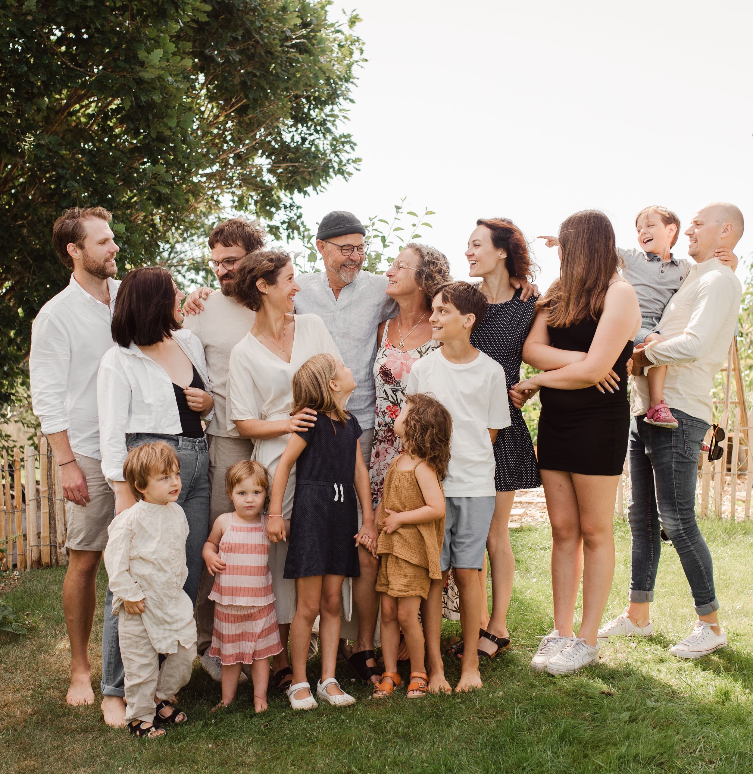 Large multi-generational family posing together for casual outdoor portrait.
