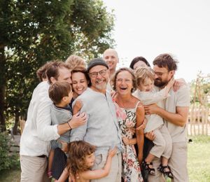 Joyful extended family sharing intimate laughs during outdoor portrait session.