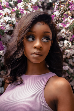 Beauty portrait with purple flowers wearing a lavender ribbed tank top.