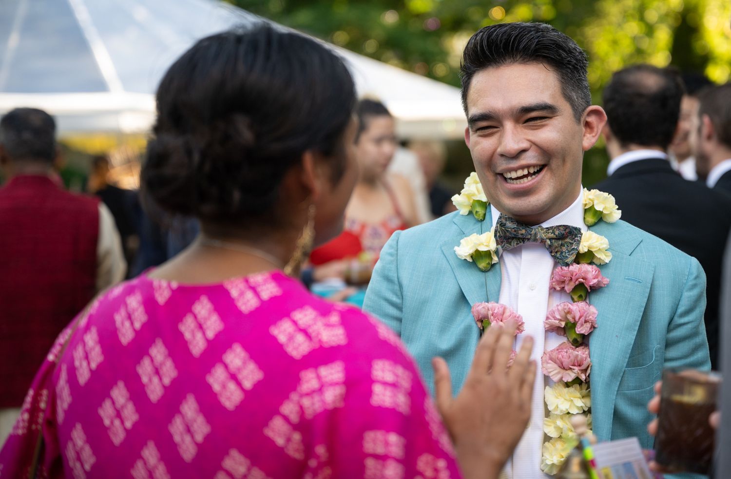 Wedding celebration outdoors with tropical floral decorations and light blue attire.