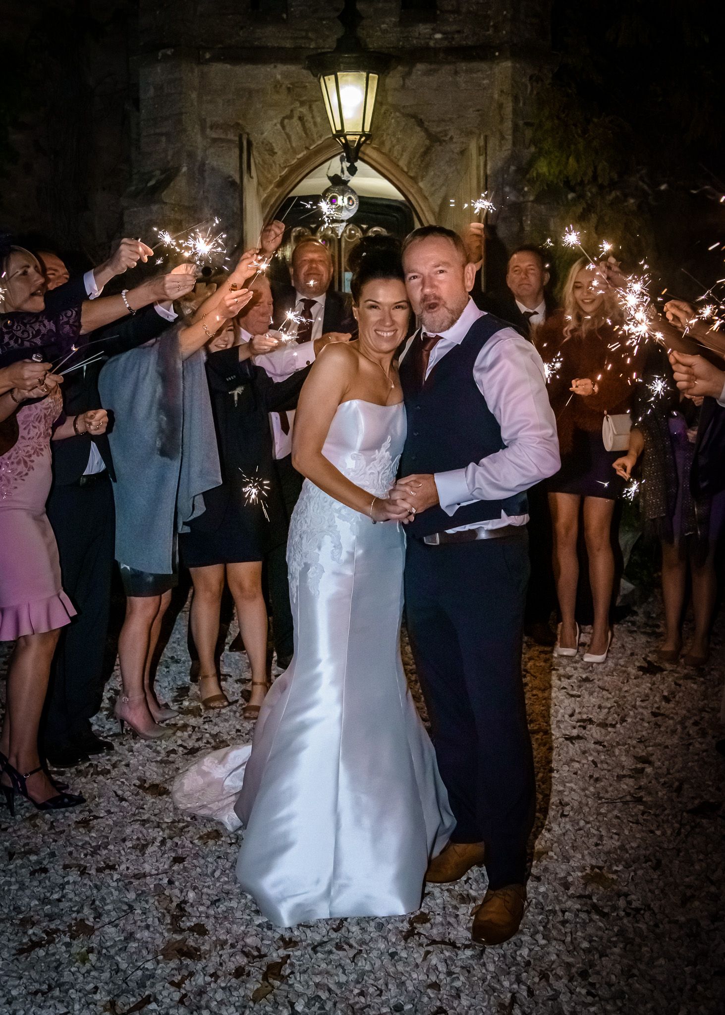 Bride and groom surrounded by quests with sparklers