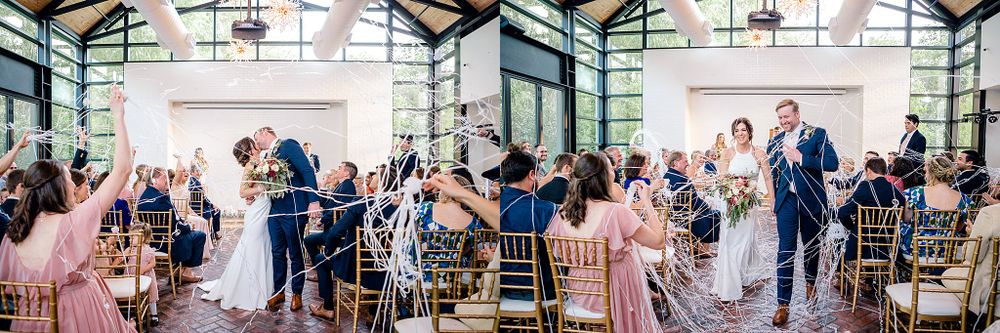 Wide panoramic view of a wedding ceremony in a bright modern venue with glass walls and high ceilings.