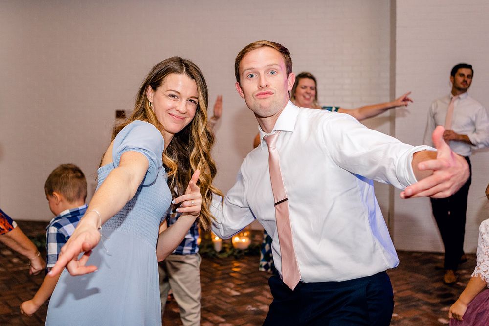 Guests enjoying playful dance moves at wedding reception.