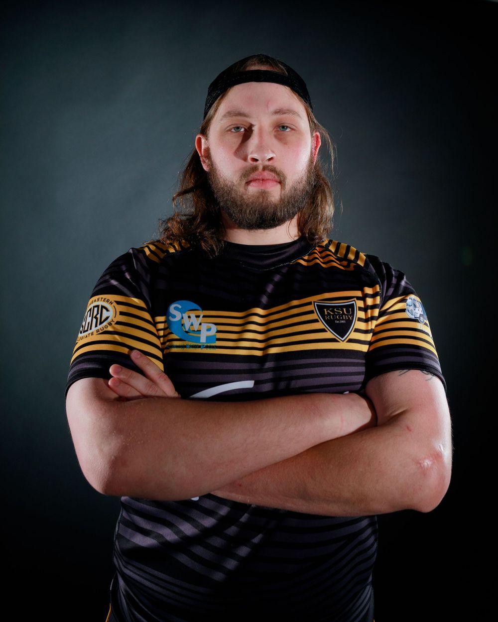 Athletes in black and yellow striped uniforms pose confidently against dark backdrop.