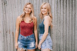 Two women stand infront of a metal wall